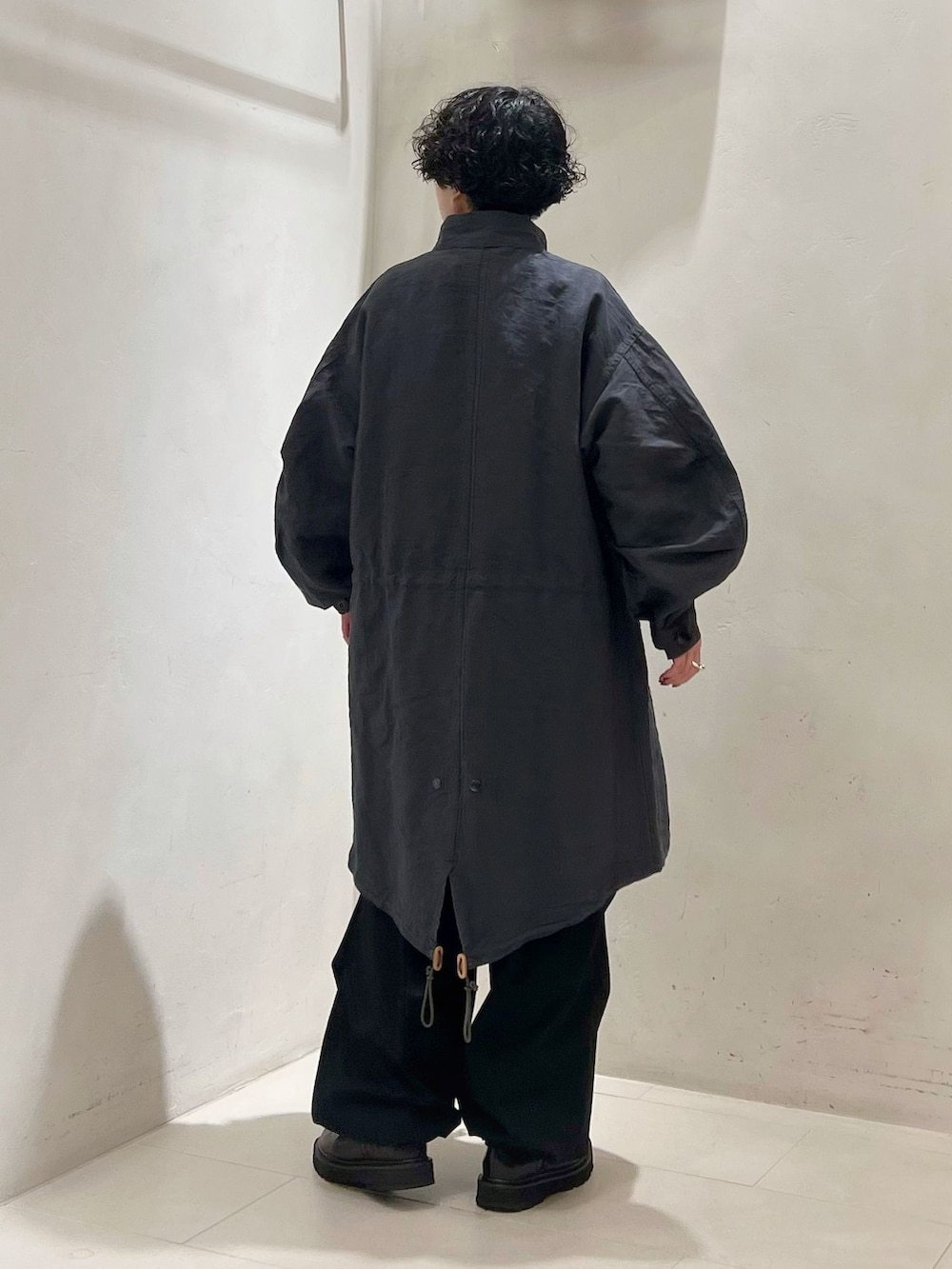 ブラック系のカーゴパンツ、ホワイト系のシャツ/ブラウス、ブラック系のニット/セーターを着用したレディースの冬コーディネートの2枚目の写真