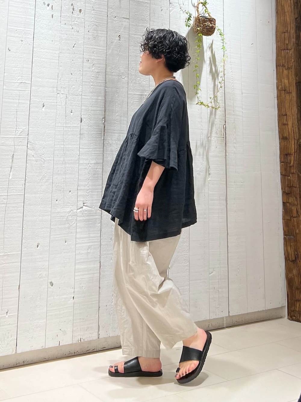 グレー系のその他パンツ、ブラック系のシャツ/ブラウス、ブラック系のかごバッグを着用したレディースの夏コーディネートの2枚目の写真