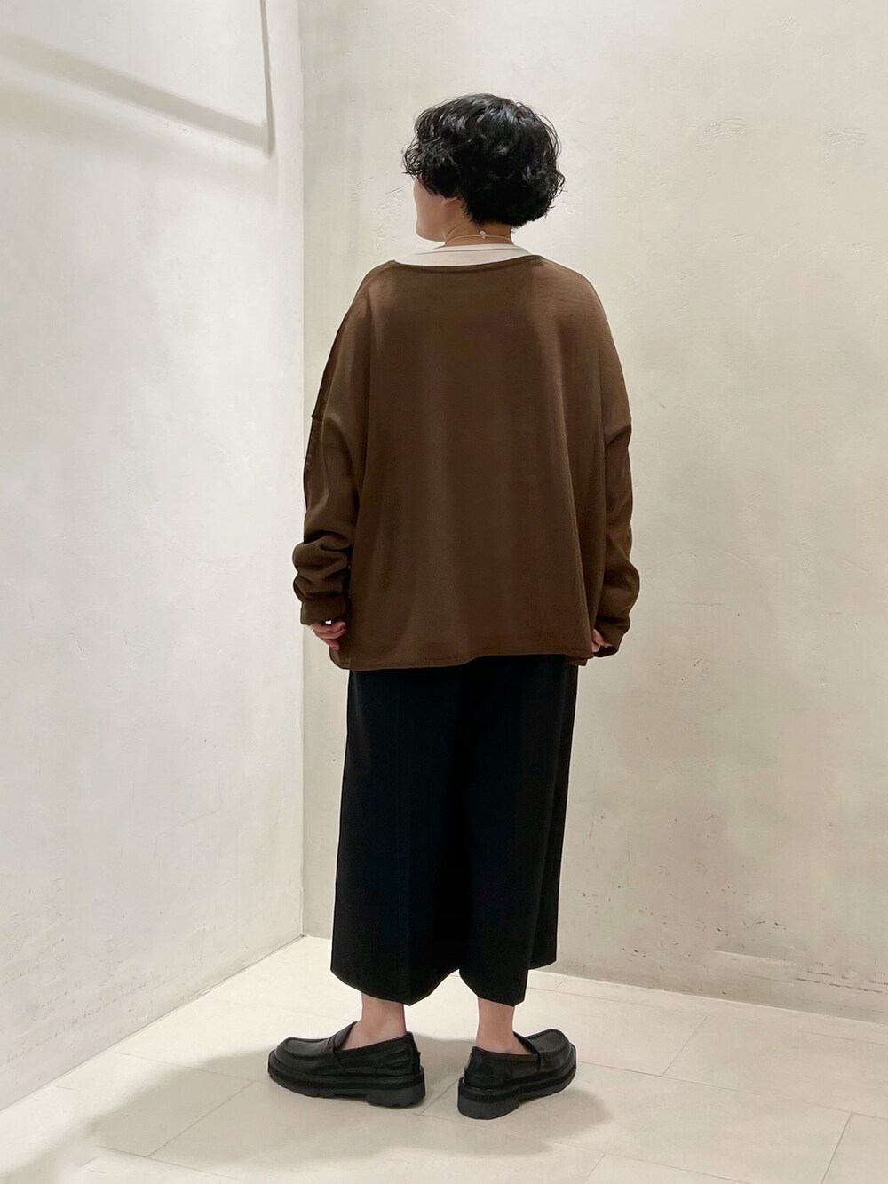 ブラック系のその他パンツ、ホワイト系のTシャツ/カットソー、ブラウン系のニット/セーターを着用したレディースの春コーディネートの6枚目の写真