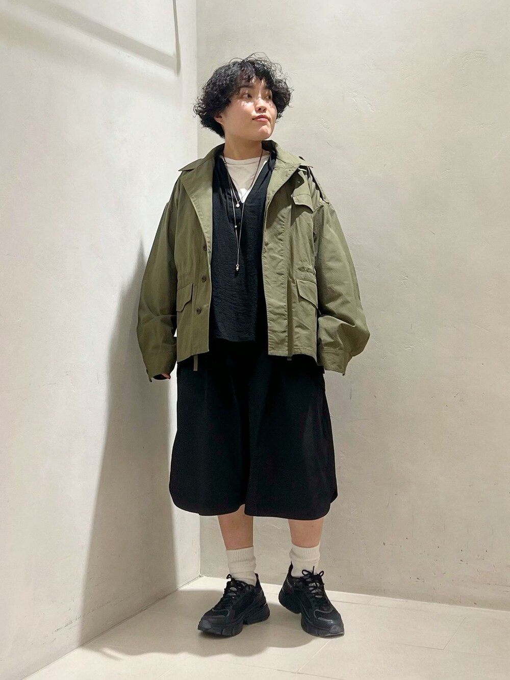 グリーン系のミリタリージャケット、ブラック系のその他パンツ、ホワイト系のTシャツ/カットソーを着用したレディースの冬コーディネートの5枚目の写真