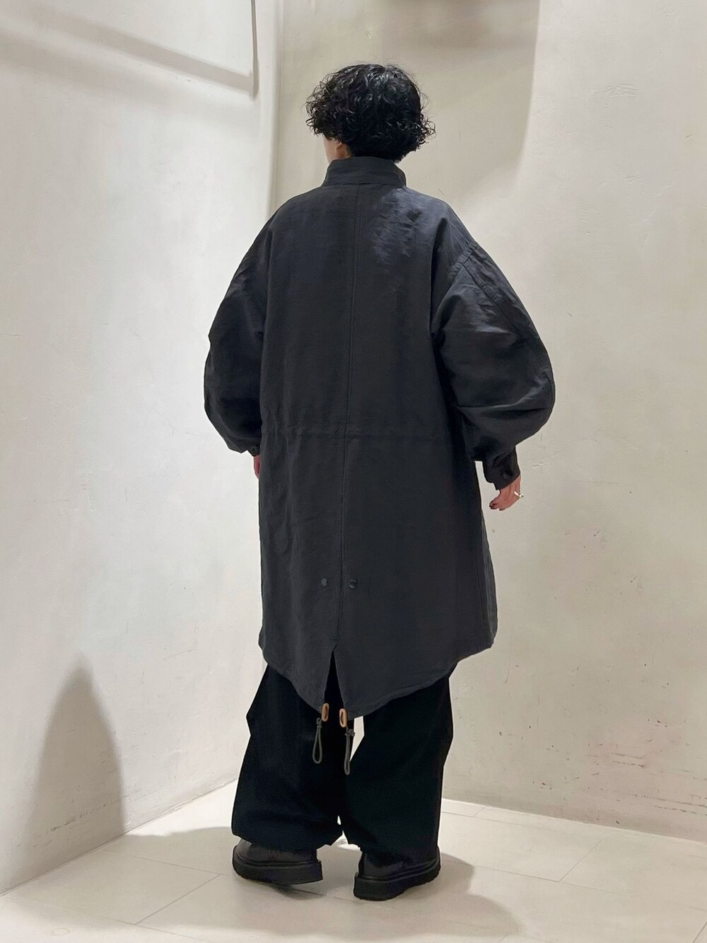 ブラック系のカーゴパンツ、ホワイト系のシャツ/ブラウス、ブラック系のニット/セーターを着用したレディースの冬コーディネートの2枚目の写真
