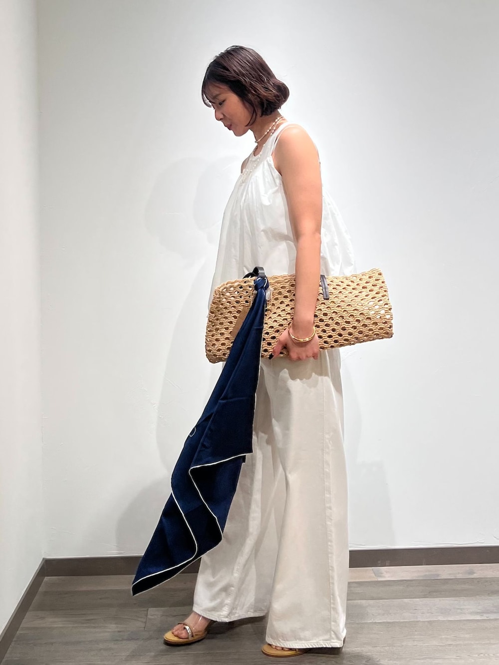 ホワイト系のデニムパンツ、ホワイト系のシャツ/ブラウス、ベージュ系のトートバッグを着用したレディースの春コーディネートの2枚目の写真