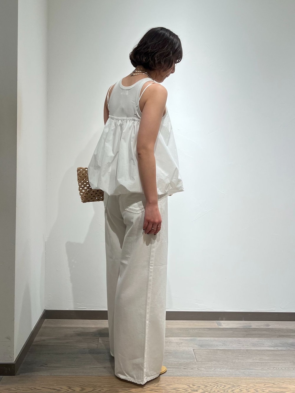 ホワイト系のデニムパンツ、ホワイト系のシャツ/ブラウス、ベージュ系のトートバッグを着用したレディースの春コーディネートの3枚目の写真