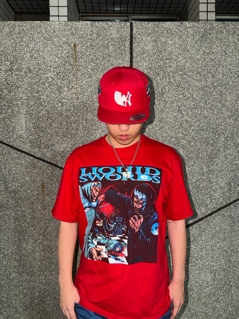 レッド系のTシャツ/カットソー、ホワイト系のスニーカー、レッド系のキャップを着用したメンズの春コーディネートの2枚目の写真