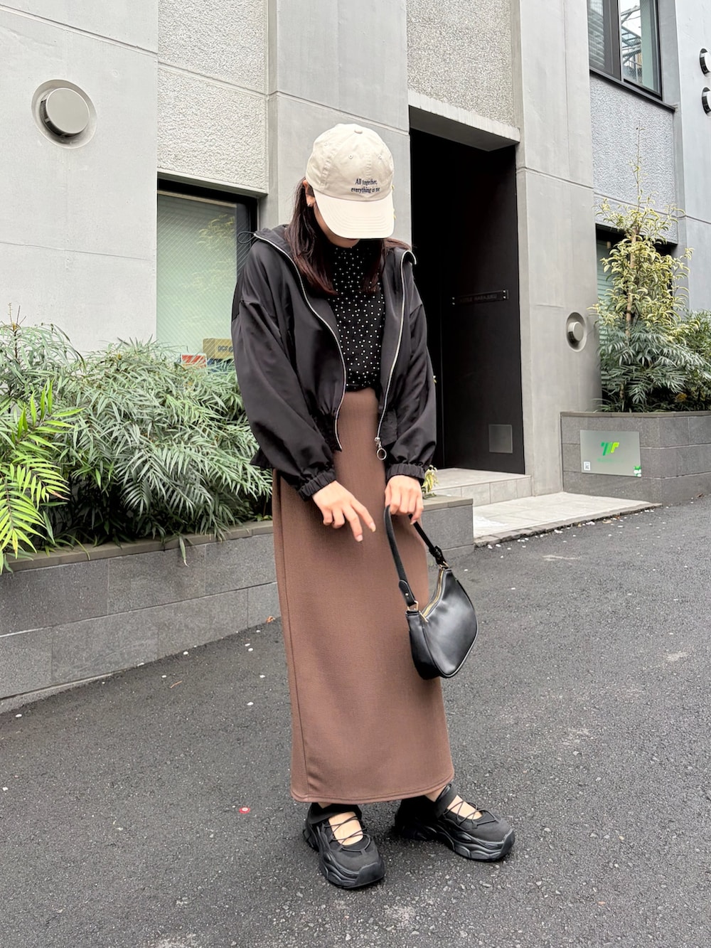 その他のTシャツ/カットソー、ブラウン系のスカート、ブラック系のマウンテンパーカーを着用したレディースの春コーディネートの2枚目の写真