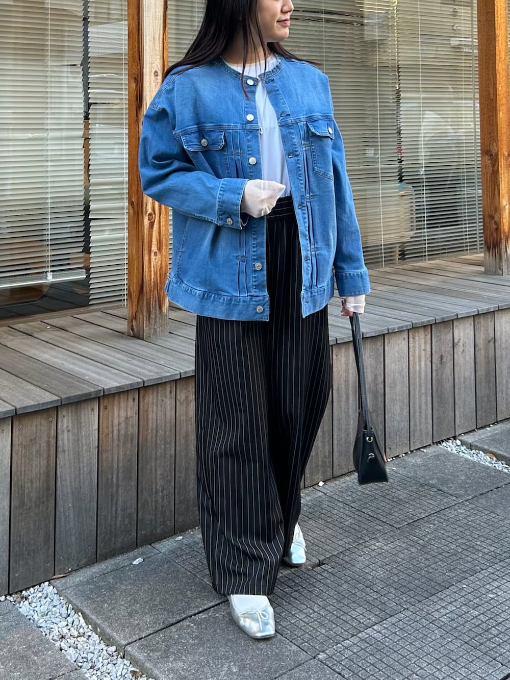 ブルー系のデニムジャケット、ホワイト系のTシャツ/カットソー、ブラック系のその他パンツを着用したレディースの春コーディネートの2枚目の写真