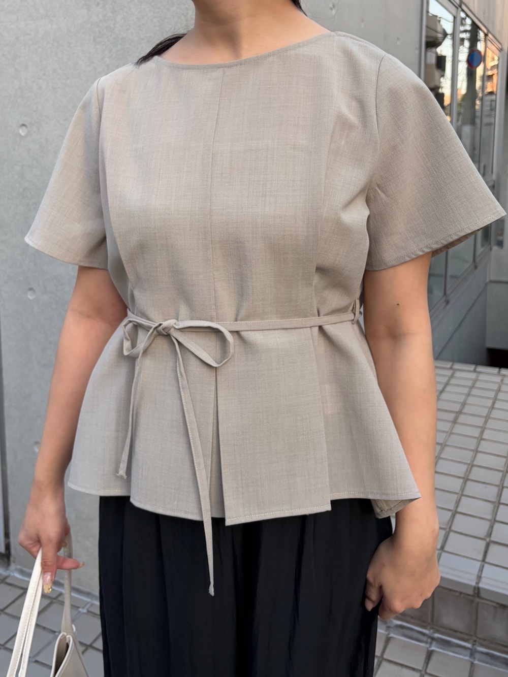 ブラック系のその他パンツ、ベージュ系のシャツ/ブラウスを着用したレディースの春コーディネートの2枚目の写真