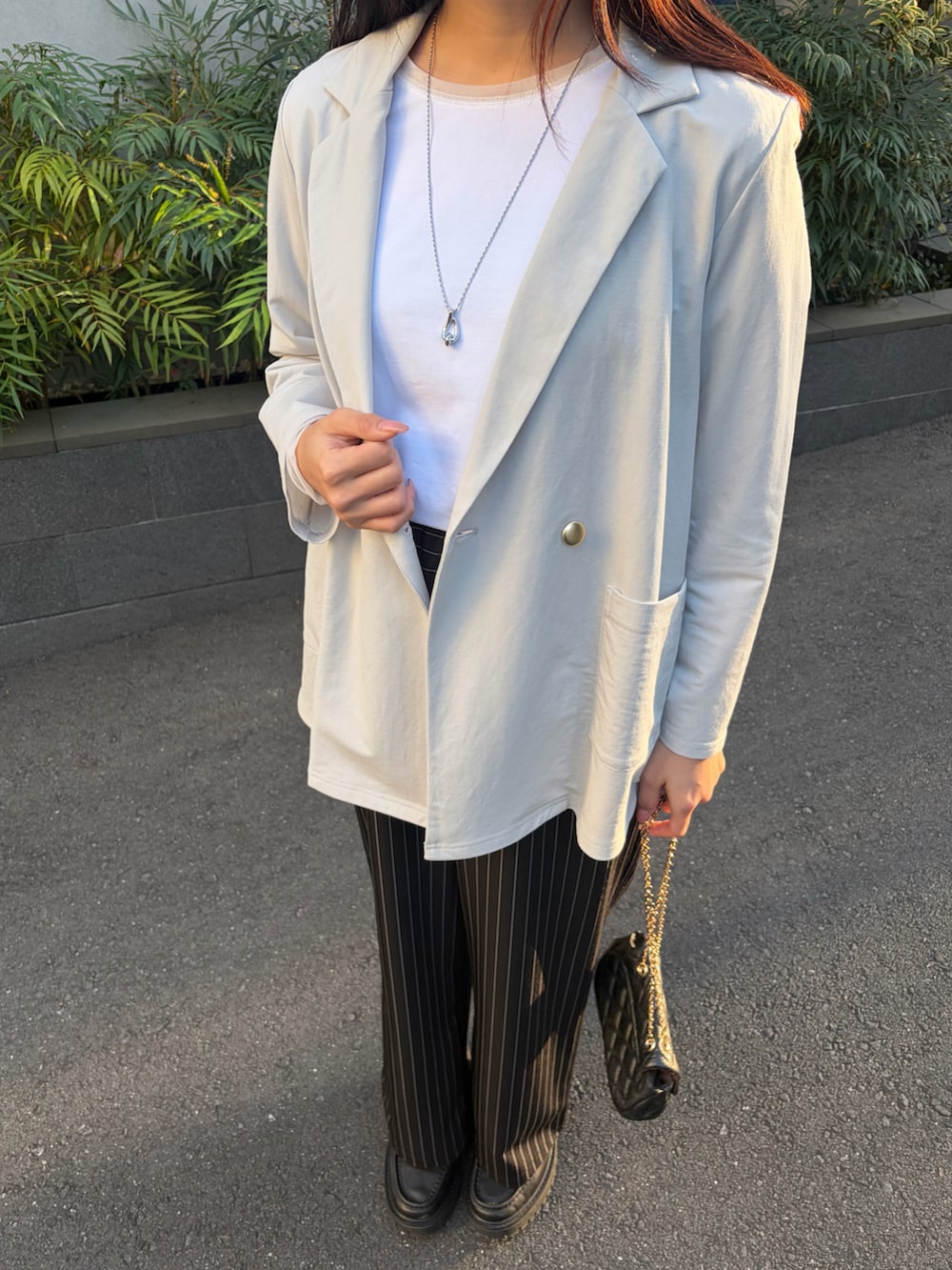 ホワイト系のTシャツ/カットソー、ブラック系のその他パンツ、グレー系のテーラードジャケットを着用したレディースの春コーディネートの4枚目の写真