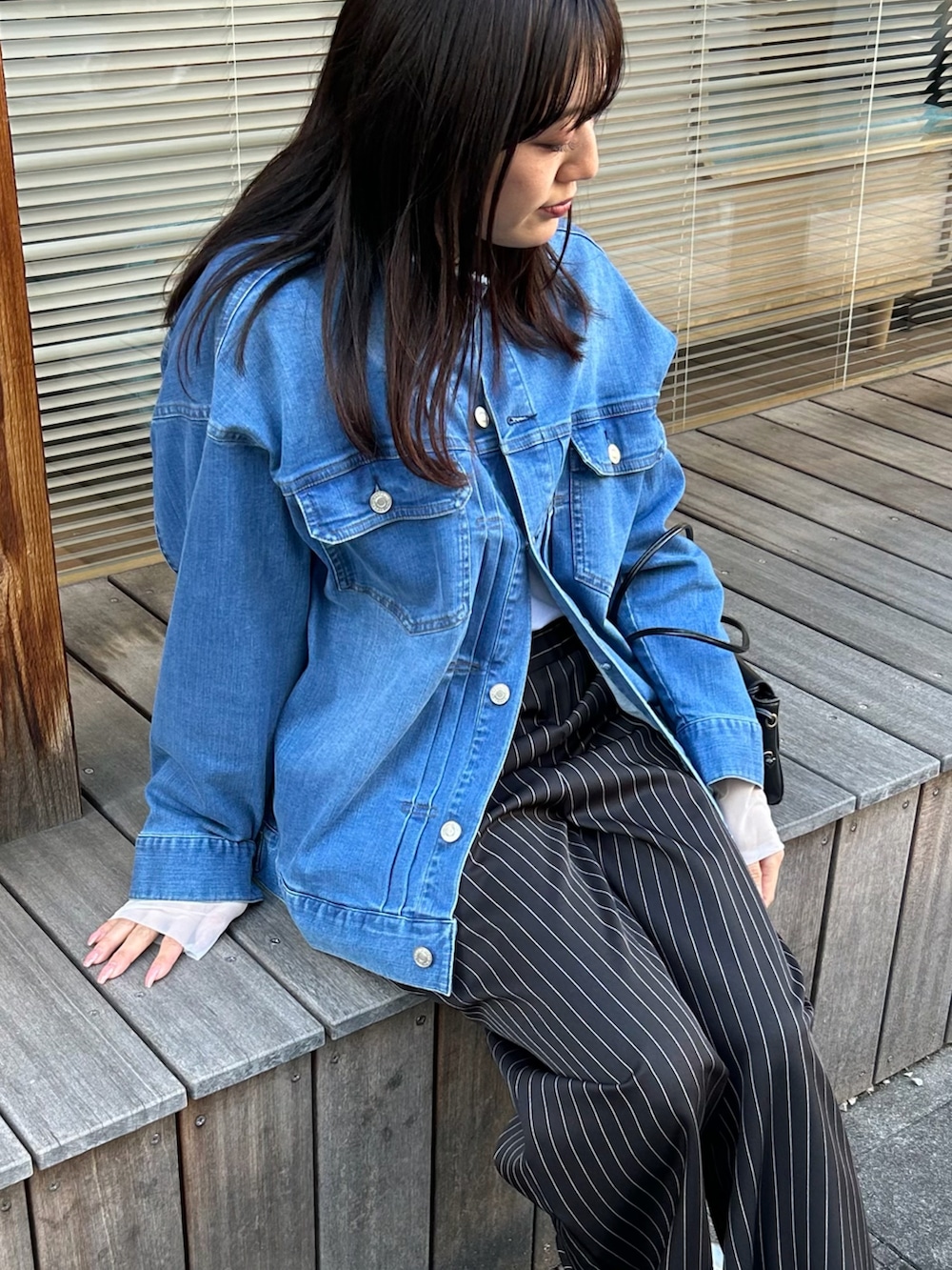 ブルー系のデニムジャケット、ホワイト系のTシャツ/カットソー、ブラック系のその他パンツを着用したレディースの春コーディネートの4枚目の写真