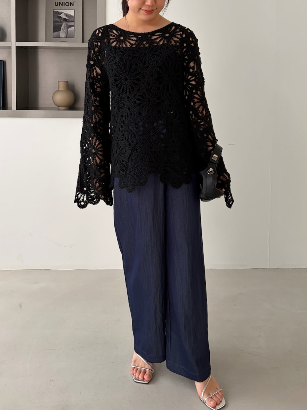 ブラック系のニット/セーターを着用したレディースの春コーディネートの2枚目の写真