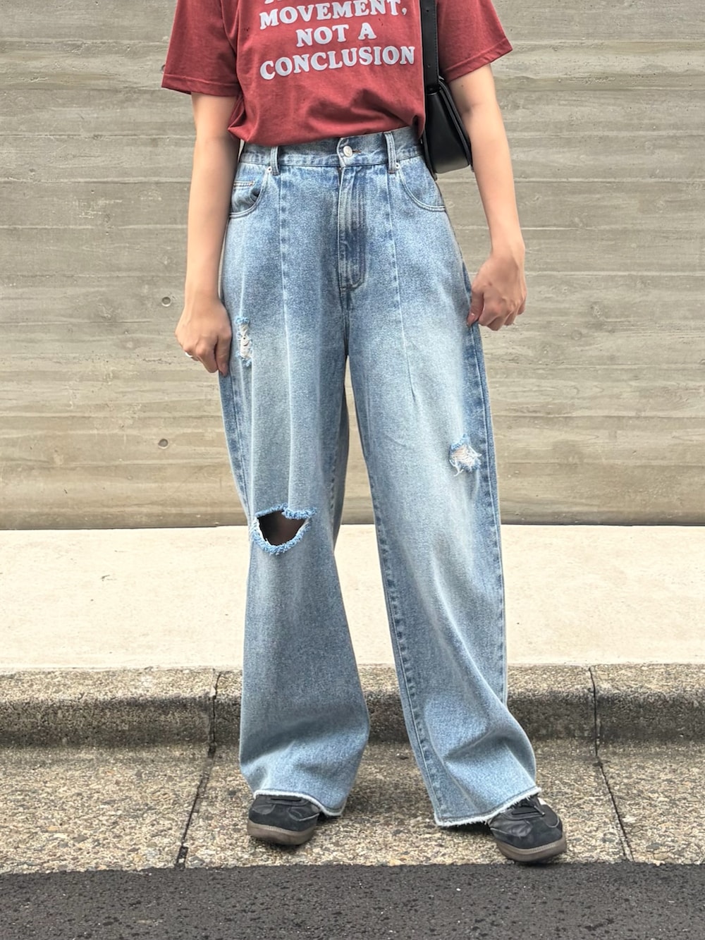 ブラウン系のTシャツ/カットソー、ブルー系のデニムパンツ、ブラック系のスニーカーを着用したレディースの夏コーディネートの4枚目の写真