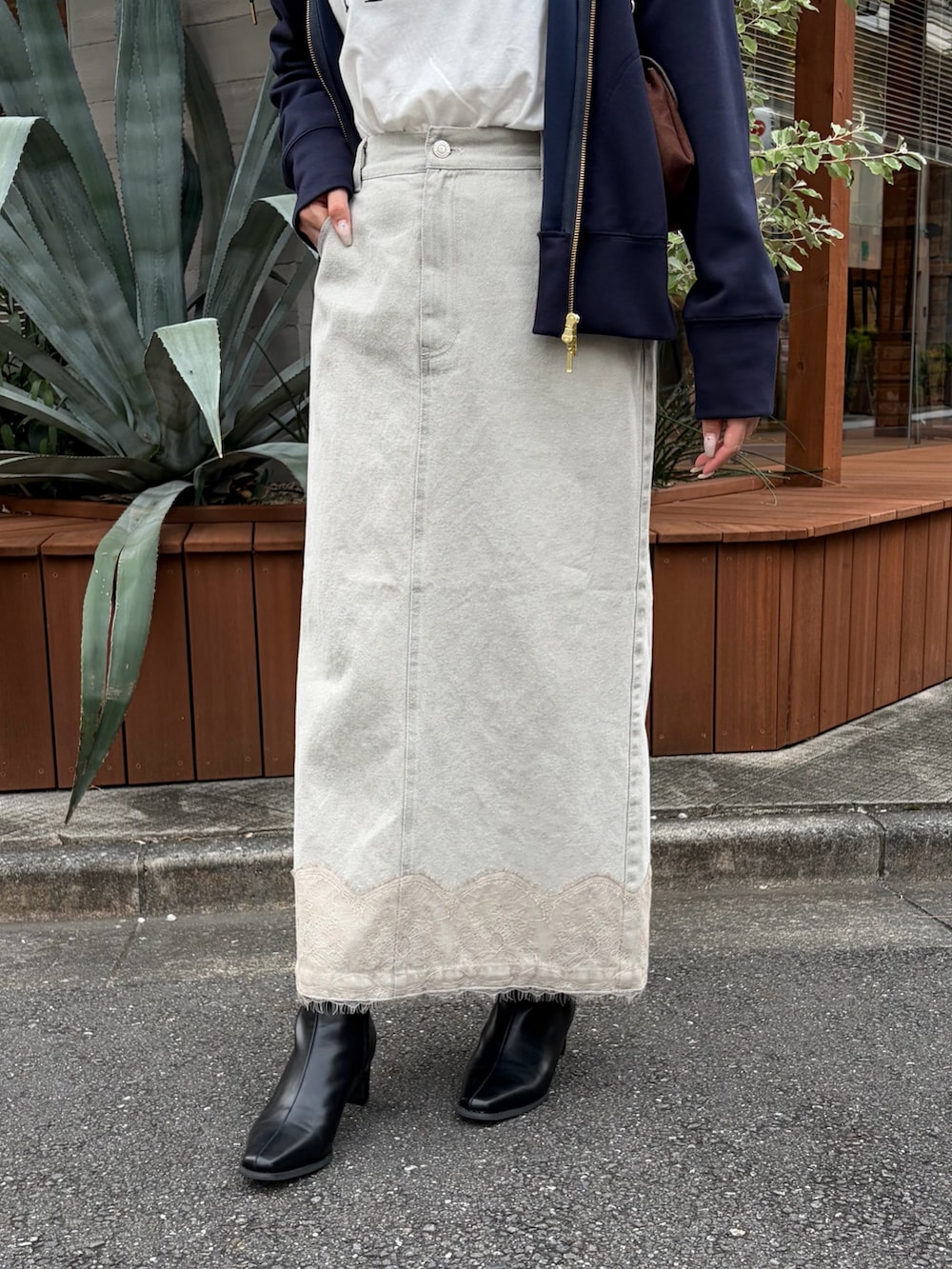ブルー系のパーカー、ベージュ系のデニムスカート、ホワイト系のTシャツ/カットソーを着用したレディースの秋コーディネートの3枚目の写真