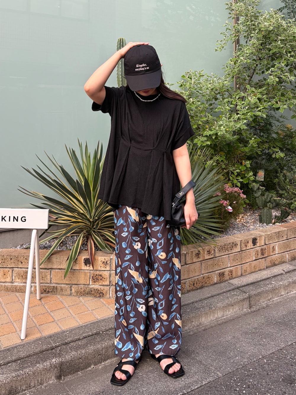 ブラック系のシャツ/ブラウス、ブラック系のサンダル、ブラウン系のその他パンツを着用したレディースの春コーディネートの2枚目の写真