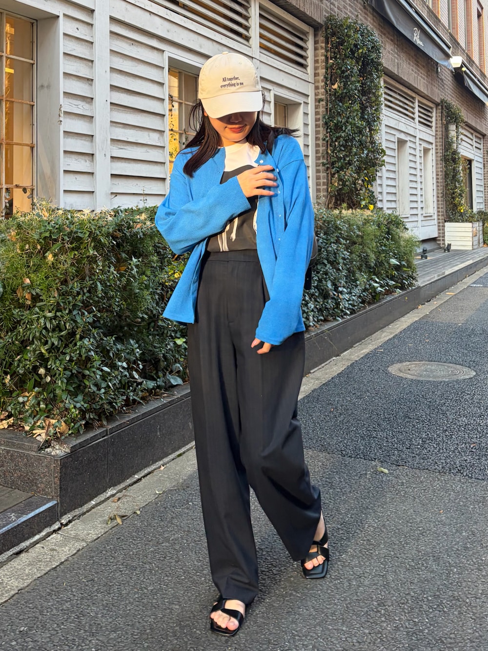 ブルー系のカーディガン/ボレロ、ホワイト系のTシャツ/カットソー、ブルー系のスラックスを着用したレディースの春コーディネートの2枚目の写真