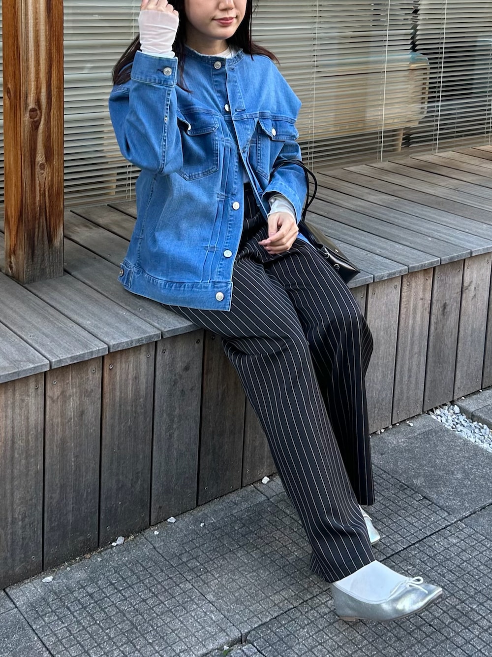 ブルー系のデニムジャケット、ホワイト系のTシャツ/カットソー、ブラック系のその他パンツを着用したレディースの春コーディネートの3枚目の写真