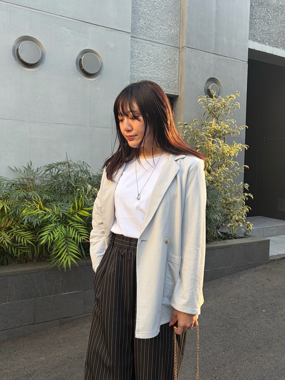 ホワイト系のTシャツ/カットソー、ブラック系のその他パンツ、グレー系のテーラードジャケットを着用したレディースの春コーディネートの2枚目の写真