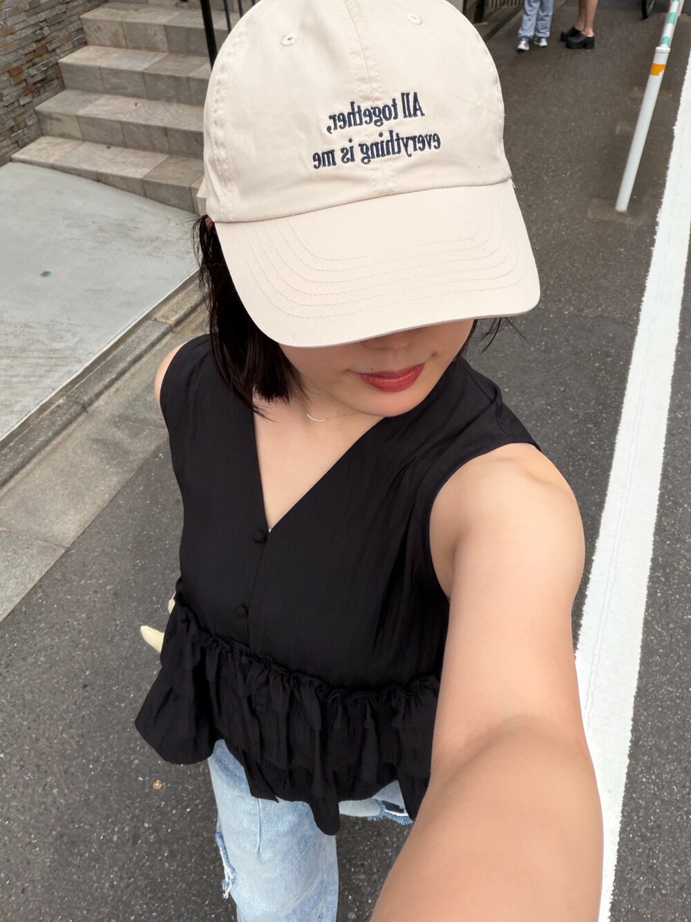 ブラック系のシャツ/ブラウス、ブルー系のデニムパンツ、ブラック系のスニーカーを着用したレディースの夏コーディネートの3枚目の写真