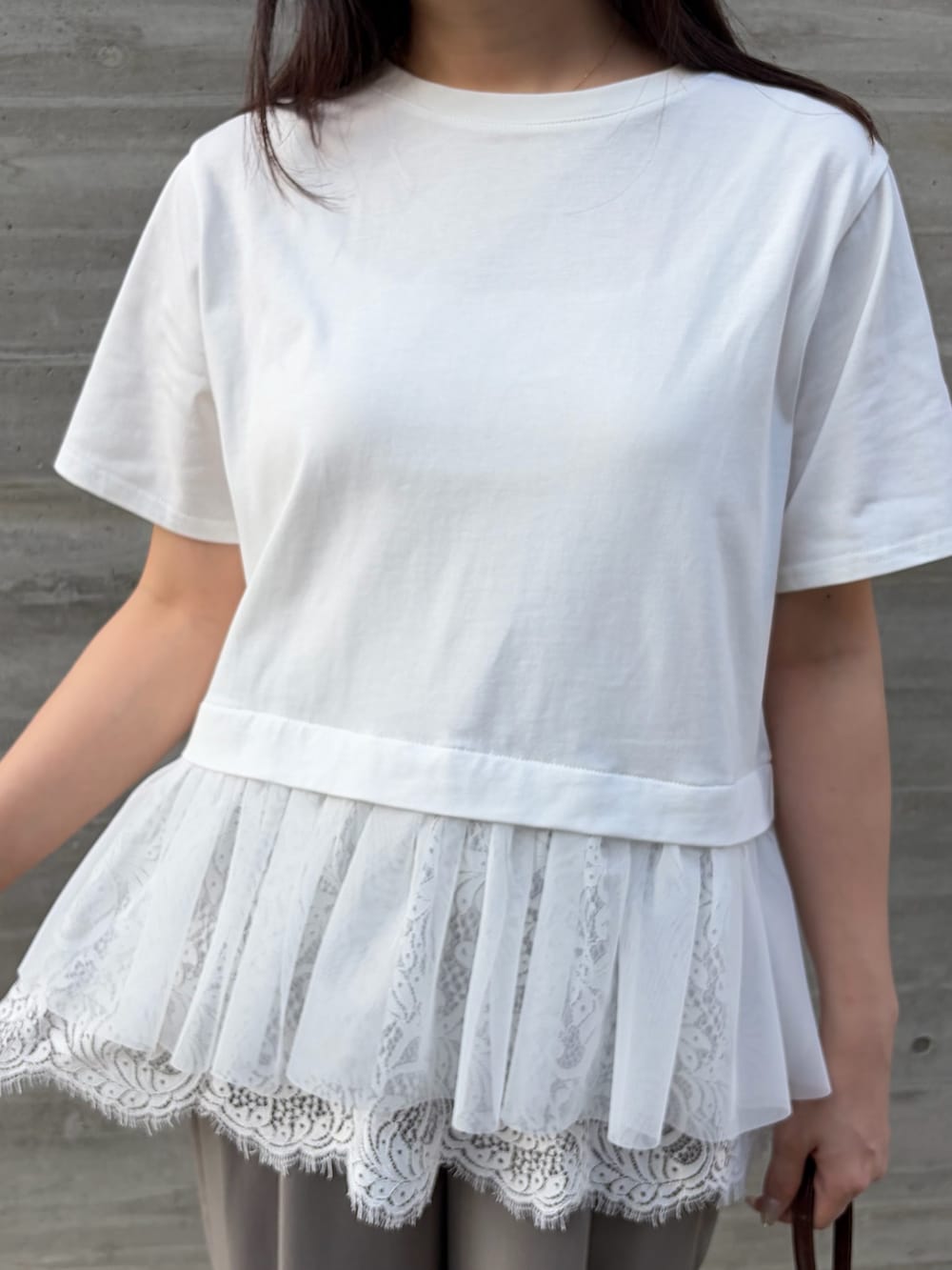 ホワイト系のTシャツ/カットソー、グレー系のスラックスを着用したレディースの夏コーディネートの2枚目の写真