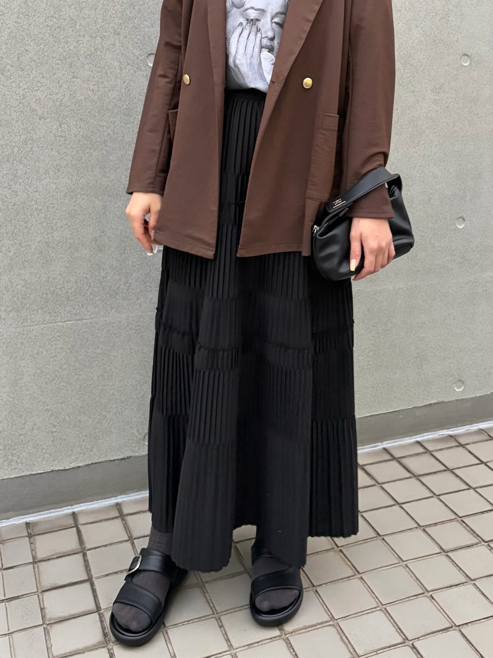 ホワイト系のTシャツ/カットソー、ブラウン系のテーラードジャケット、ブラック系のスカートを着用したレディースの春コーディネートの4枚目の写真