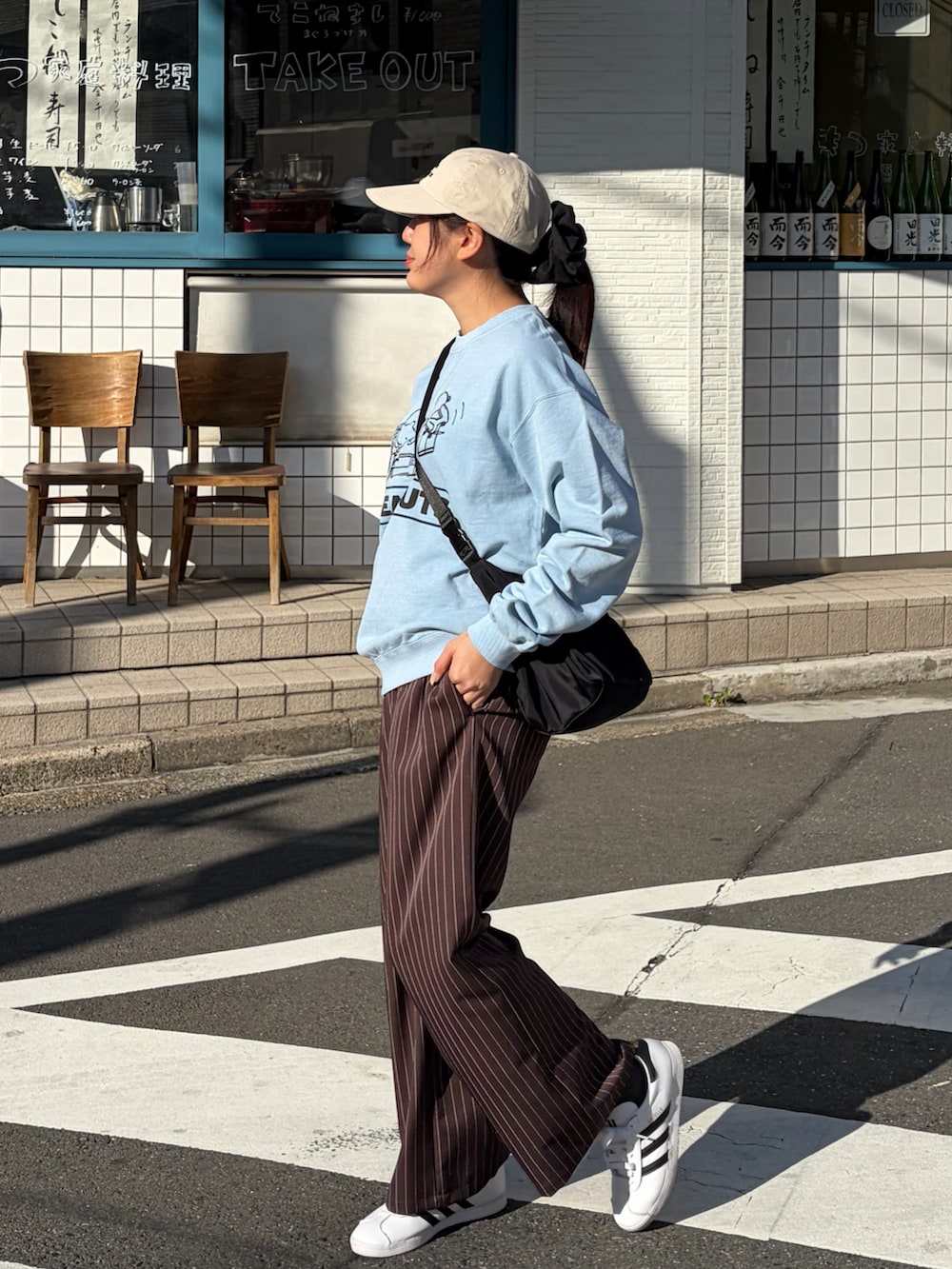 ブラック系のショルダーバッグ、ブラウン系のその他パンツ、ブルー系のスウェットを着用したレディースの春コーディネートの2枚目の写真