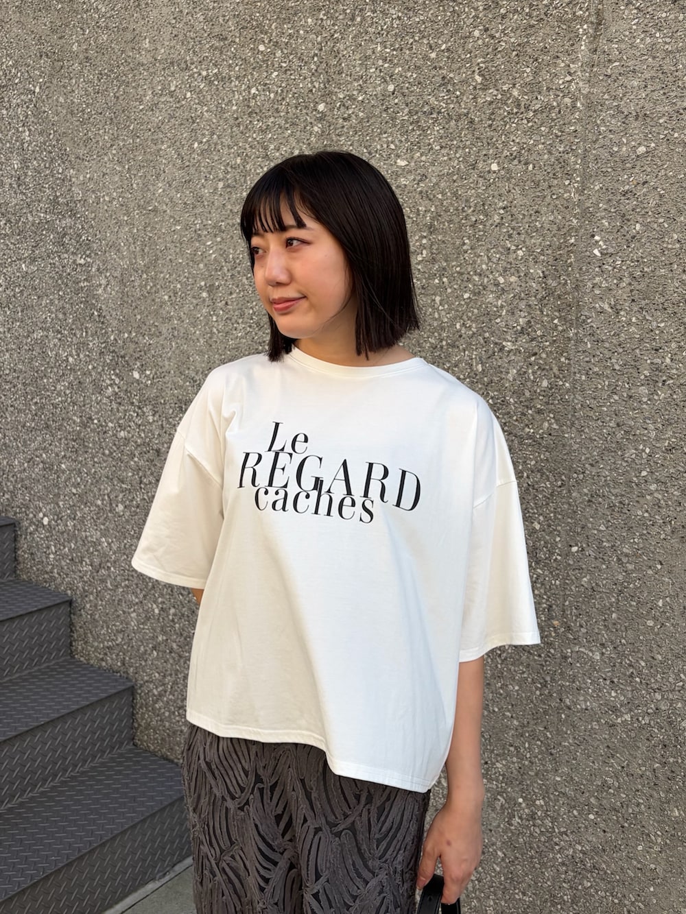 ホワイト系のTシャツ/カットソー、グレー系のスカート、ブラック系のサンダルを着用したレディースの夏コーディネートの3枚目の写真