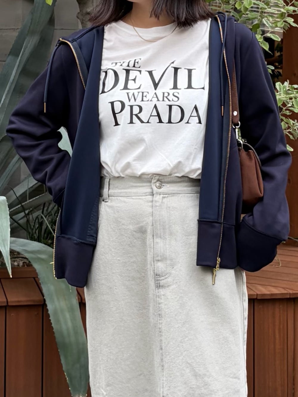 ブルー系のパーカー、ベージュ系のデニムスカート、ホワイト系のTシャツ/カットソーを着用したレディースの秋コーディネートの2枚目の写真