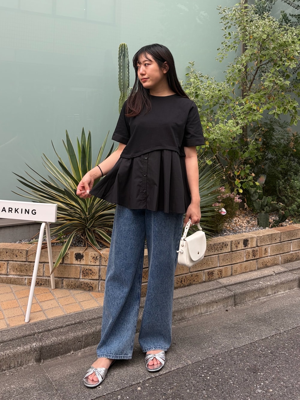 ブラック系のTシャツ/カットソー、ブルー系のデニムパンツを着用したレディースの夏コーディネートの2枚目の写真