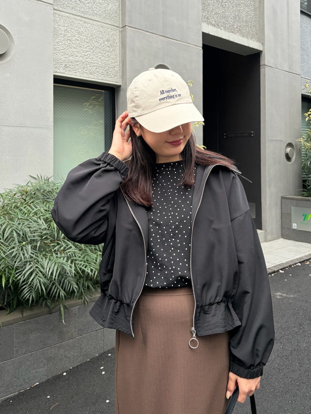 その他のTシャツ/カットソー、ブラウン系のスカート、ブラック系のマウンテンパーカーを着用したレディースの春コーディネートの3枚目の写真