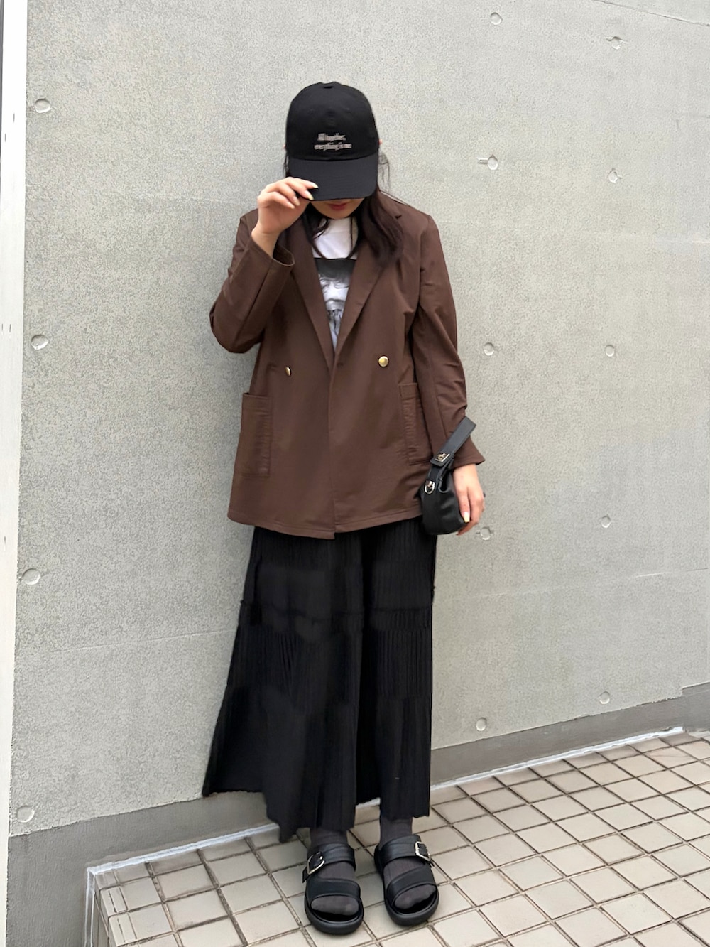 ホワイト系のTシャツ/カットソー、ブラウン系のテーラードジャケット、ブラック系のスカートを着用したレディースの春コーディネートの2枚目の写真