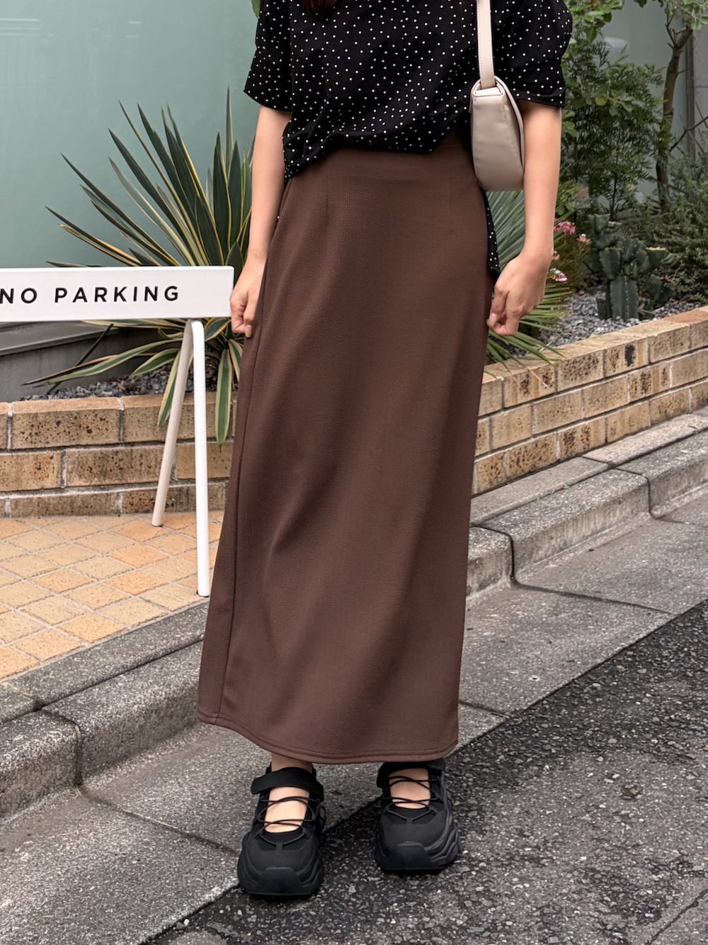 その他のTシャツ/カットソー、ブラウン系のスカート、ブラック系のスニーカーを着用したレディースの春コーディネートの3枚目の写真