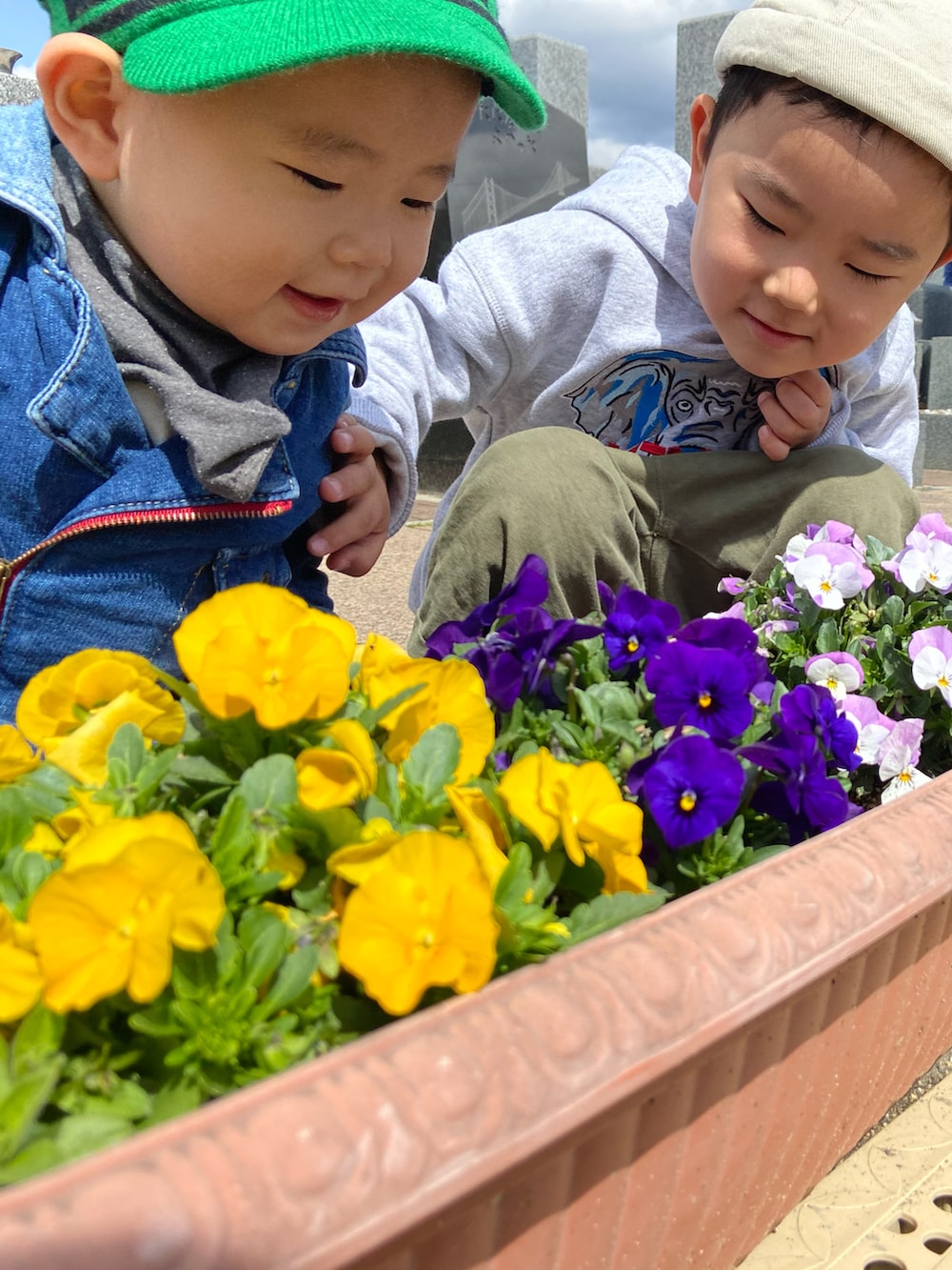 ブルー系のつなぎ/オールインワン、ブラック系のスニーカー、グリーン系のサンバイザーを着用したキッズの春コーディネートの2枚目の写真