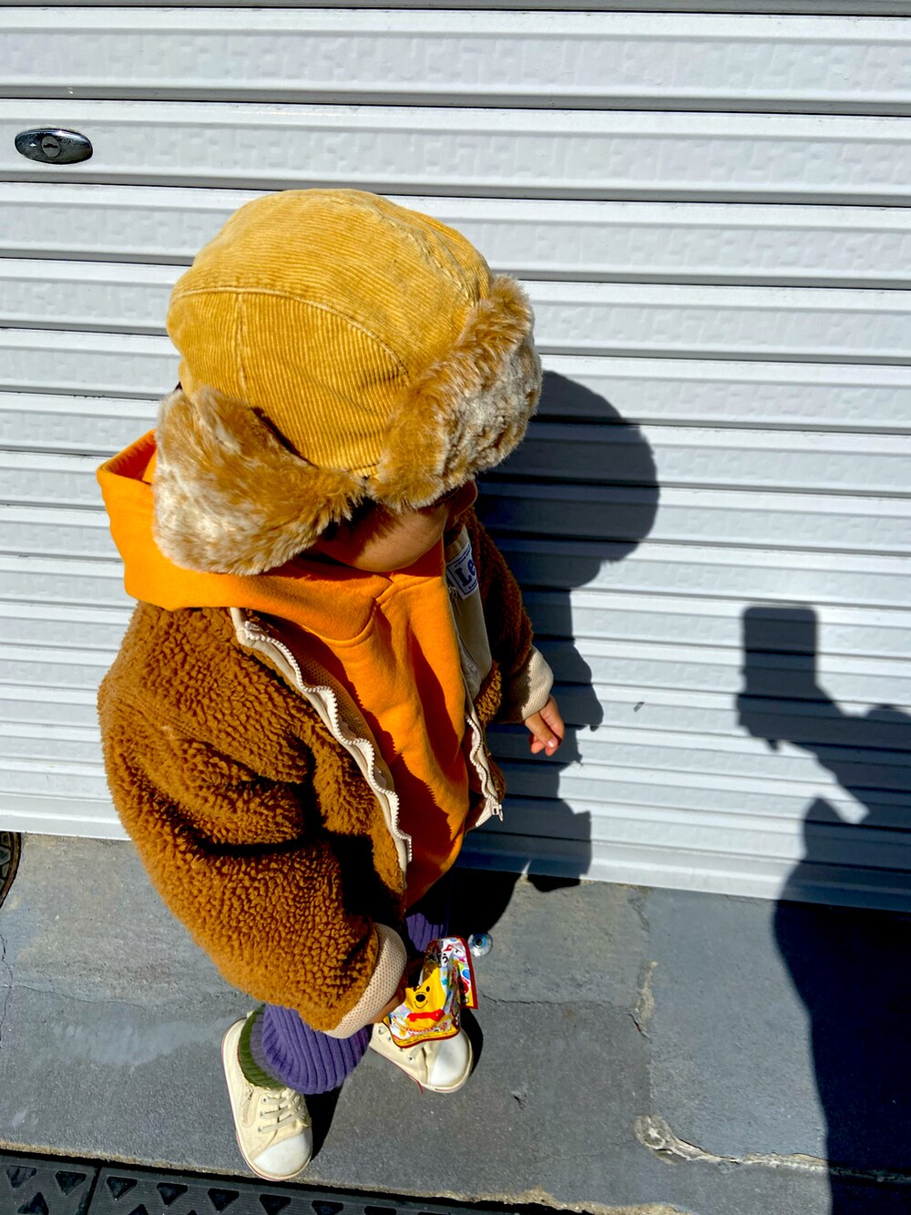 ブラウン系のブルゾン、その他のその他パンツ、オレンジ系のパーカーを着用したキッズの冬コーディネートの2枚目の写真