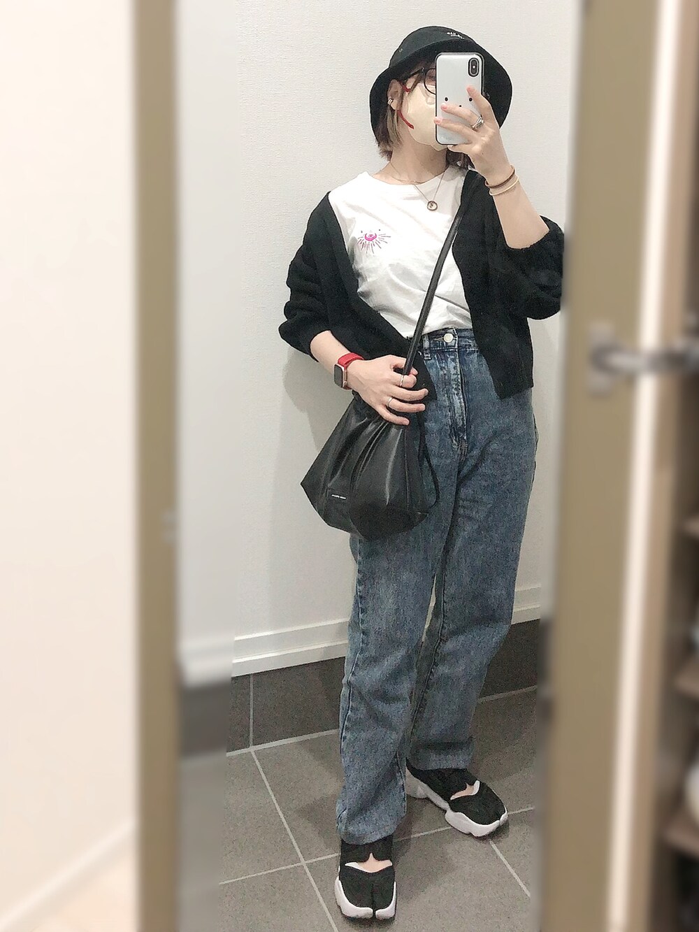 ブルー系のデニムパンツ、ブラック系のスニーカー、ブラック系のカーディガン/ボレロを着用したレディースの夏コーディネートの2枚目の写真