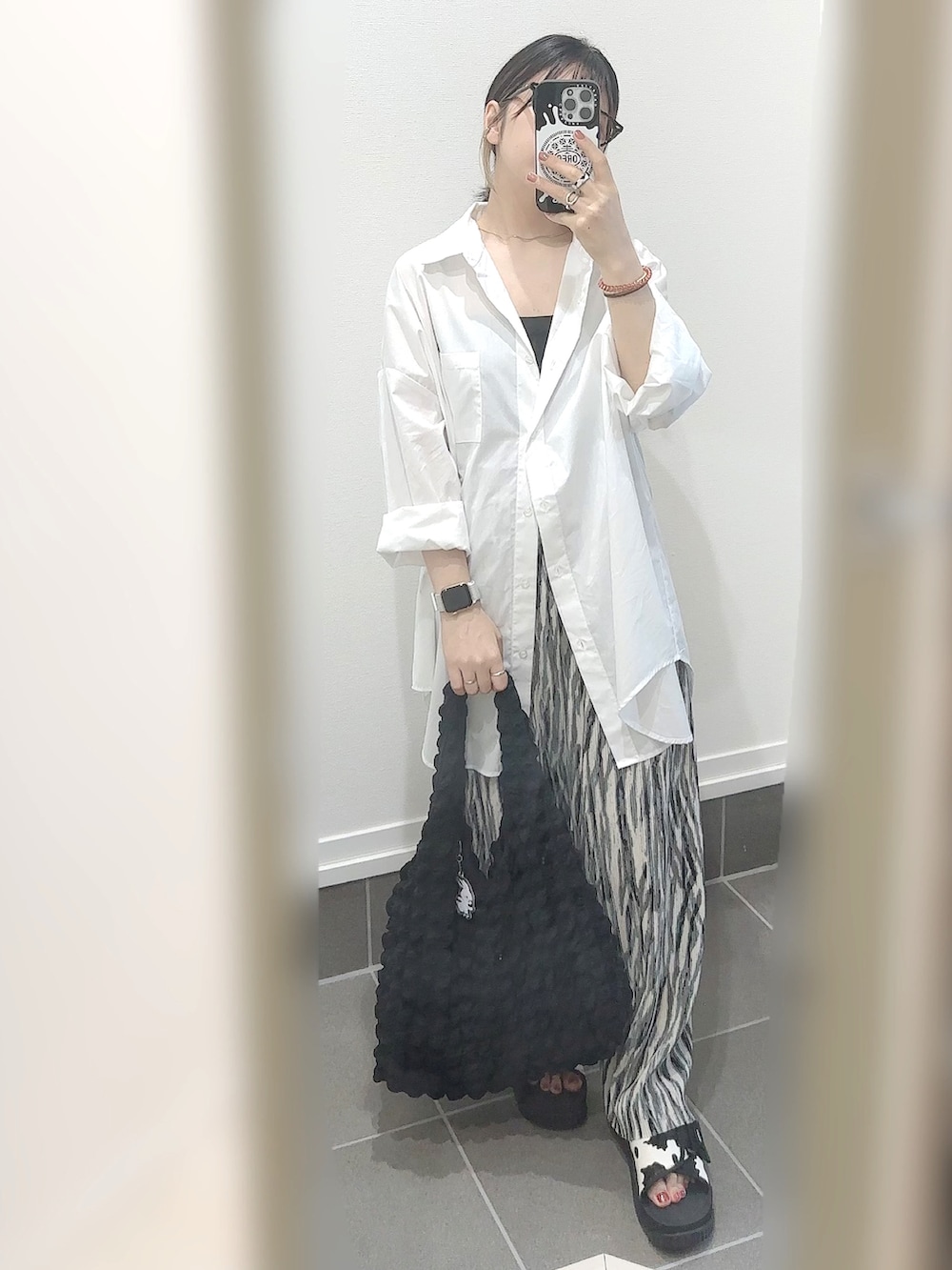 ブラック系のサンダル、グレー系のその他パンツ、ブラック系のトートバッグを着用したレディースの夏コーディネートの4枚目の写真