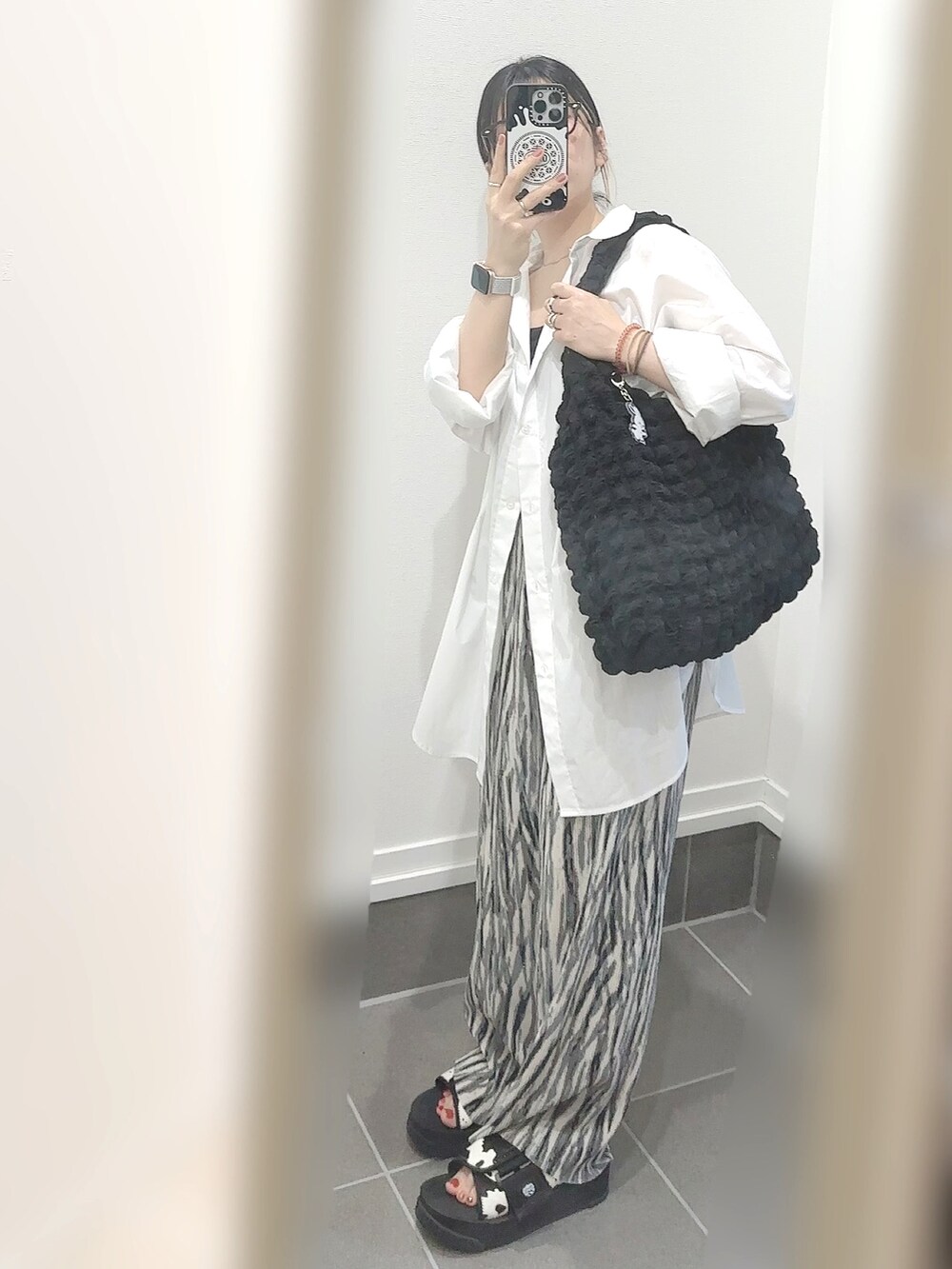 ブラック系のサンダル、グレー系のその他パンツ、ブラック系のトートバッグを着用したレディースの夏コーディネートの3枚目の写真