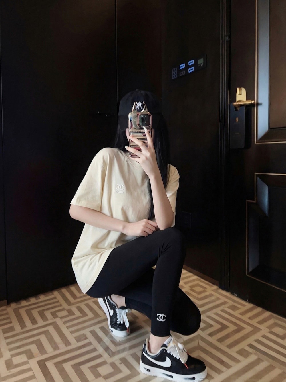 ベージュ系のTシャツ/カットソー、ブラック系のチノパンツ、ベージュ系のトートバッグを着用したレディースの春コーディネートの3枚目の写真