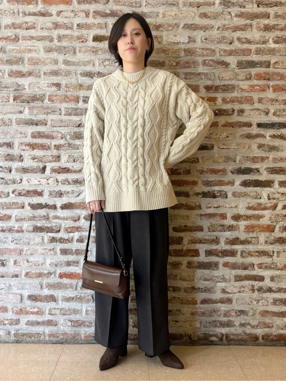 ベージュ系のその他アウター、ホワイト系のニット/セーター、ブラック系のその他パンツを着用したレディースの冬コーディネートの6枚目の写真