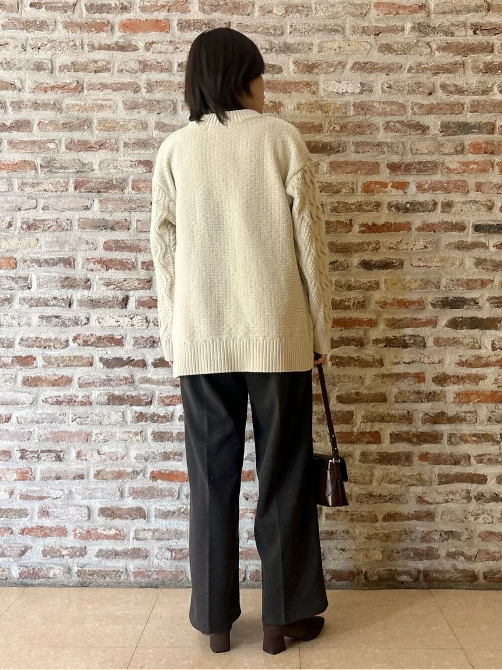 ベージュ系のその他アウター、ホワイト系のニット/セーター、ブラック系のその他パンツを着用したレディースの冬コーディネートの7枚目の写真