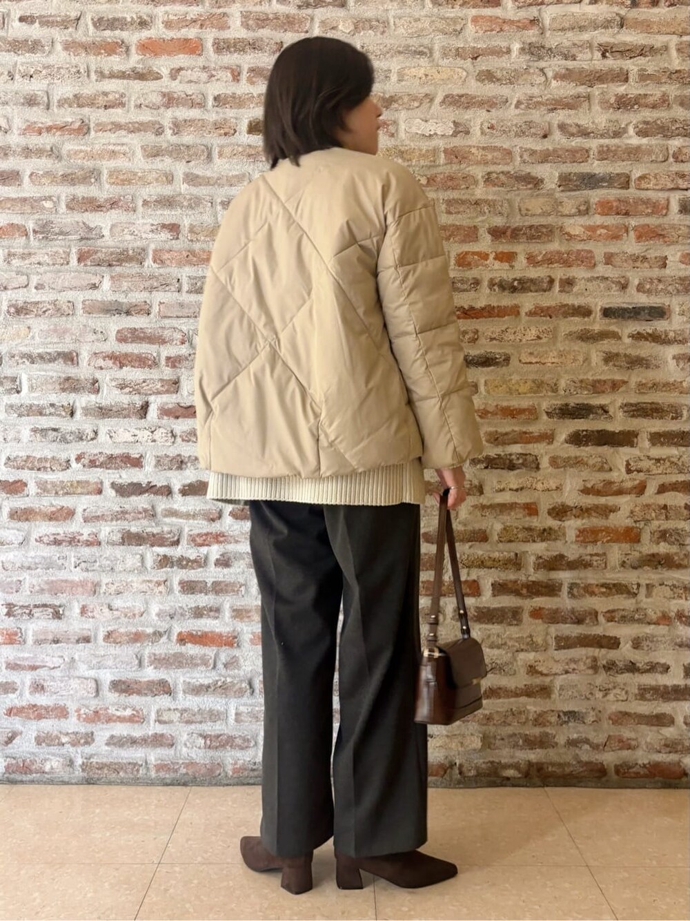ベージュ系のその他アウター、ホワイト系のニット/セーター、ブラック系のその他パンツを着用したレディースの冬コーディネートの5枚目の写真