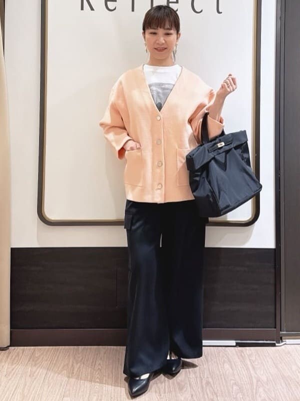 ブラック系のその他パンツ、ホワイト系のTシャツ/カットソー、オレンジ系のカーディガン/ボレロを着用したレディースの春コーディネートの4枚目の写真