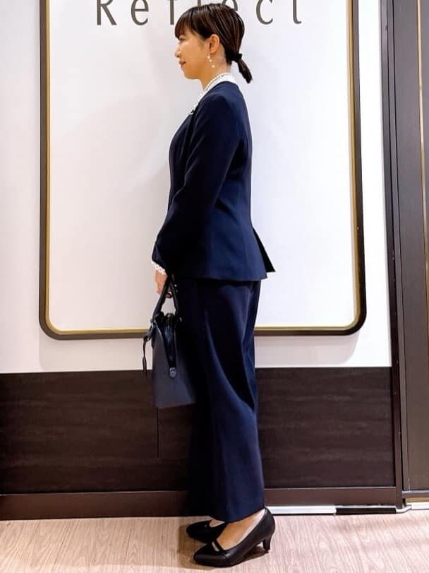 ブルー系のノーカラージャケット、ホワイト系のシャツ/ブラウス、ブルー系のハンドバッグを着用したレディースの冬コーディネートの2枚目の写真