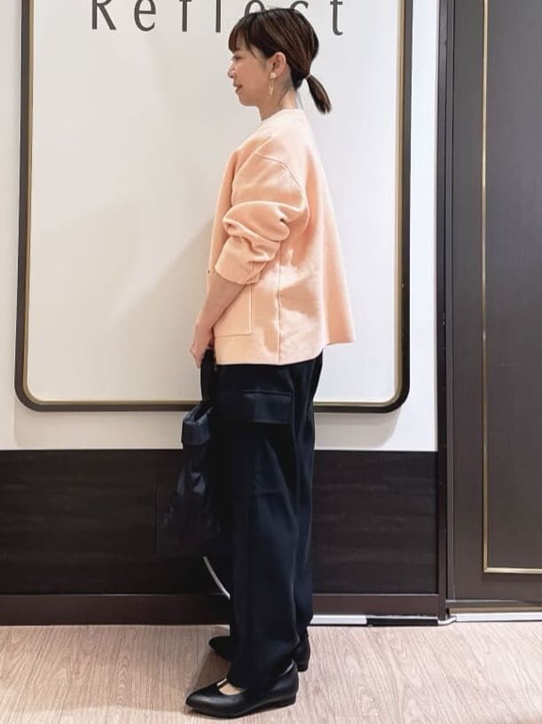 ブラック系のその他パンツ、ホワイト系のTシャツ/カットソー、オレンジ系のカーディガン/ボレロを着用したレディースの春コーディネートの2枚目の写真
