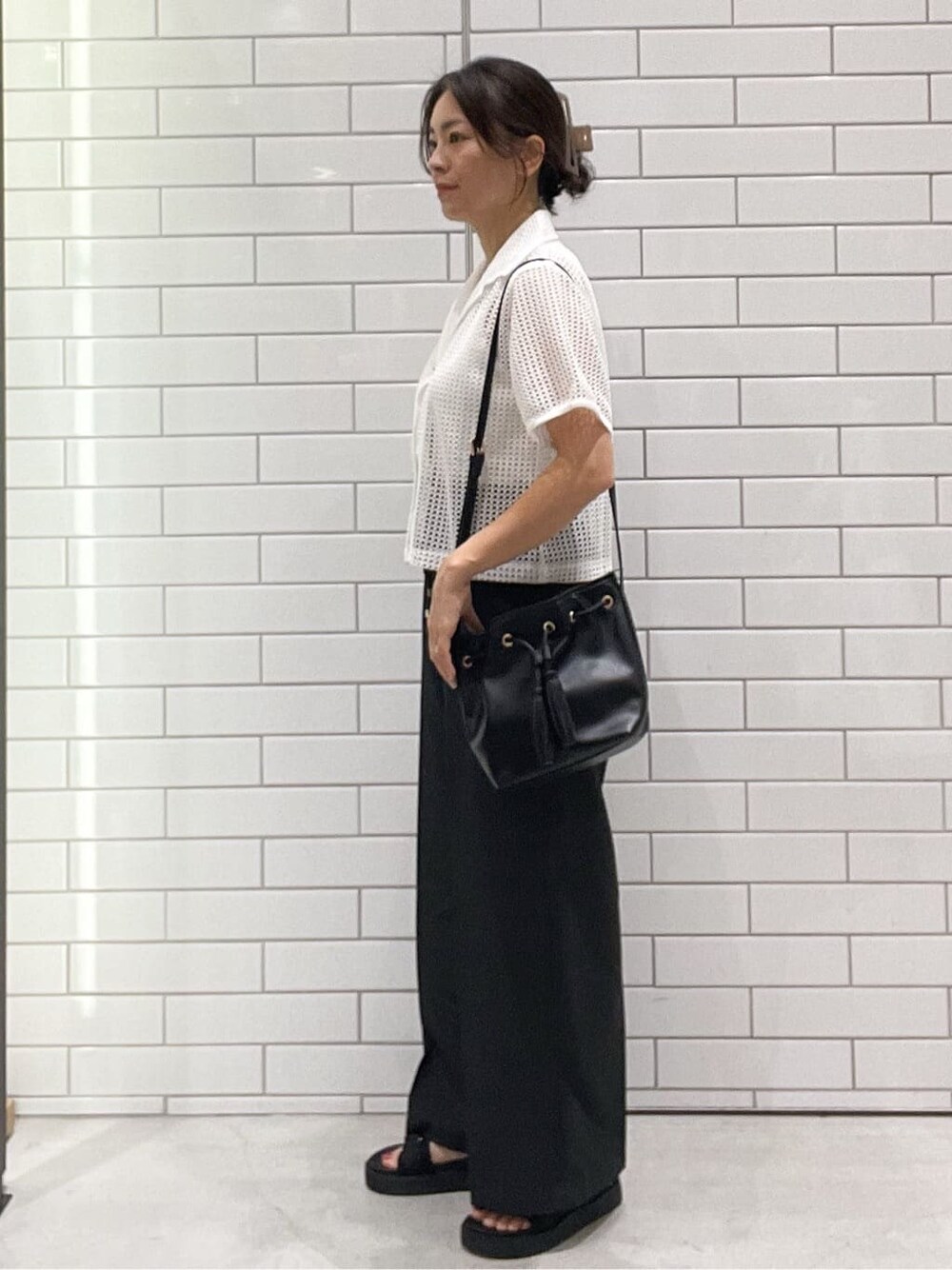 ホワイト系のシャツ/ブラウス、グレー系のその他パンツ、ブラック系のショルダーバッグを着用したレディースの夏コーディネートの4枚目の写真