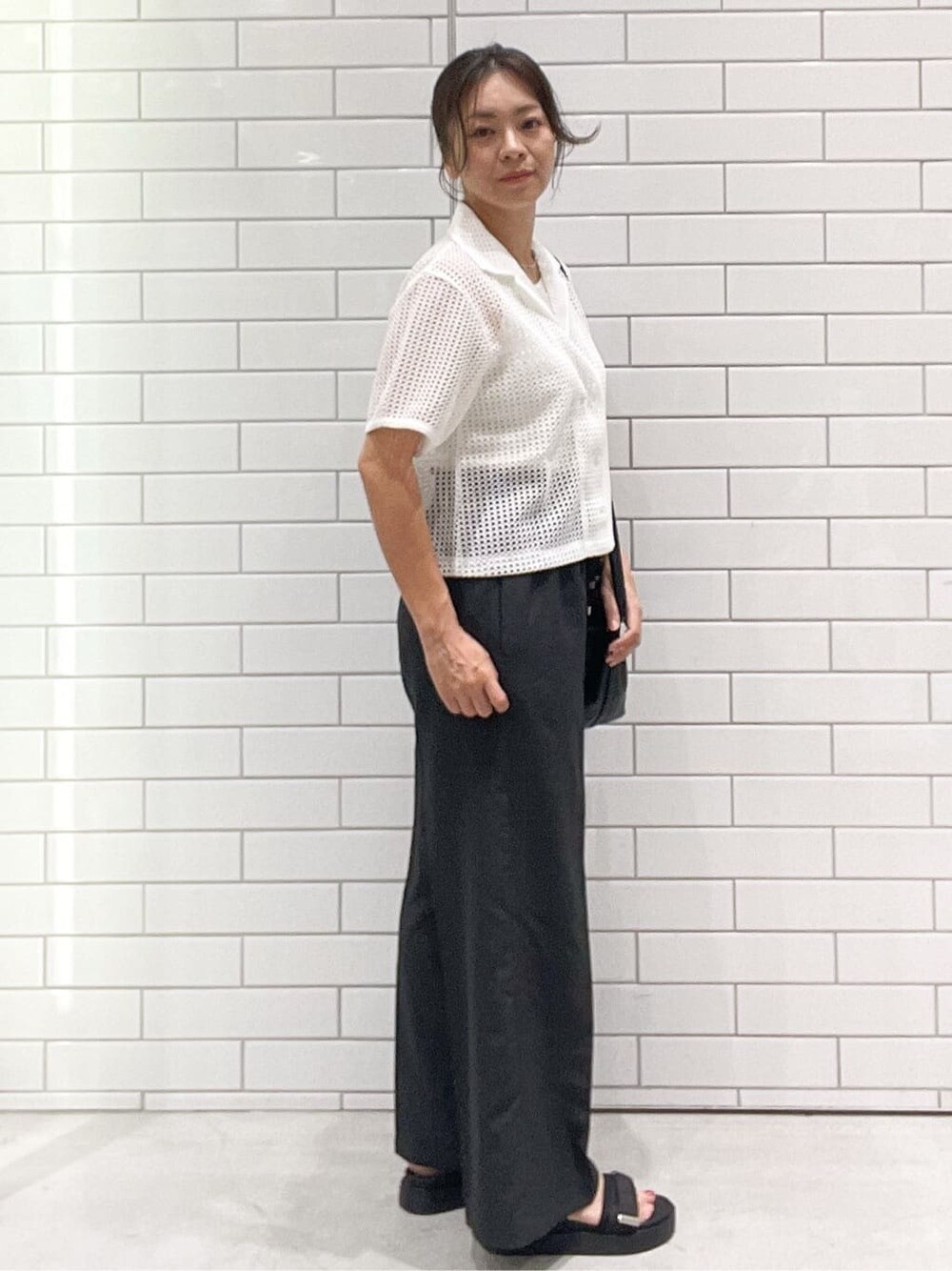 ホワイト系のシャツ/ブラウス、グレー系のその他パンツ、ブラック系のショルダーバッグを着用したレディースの夏コーディネートの3枚目の写真