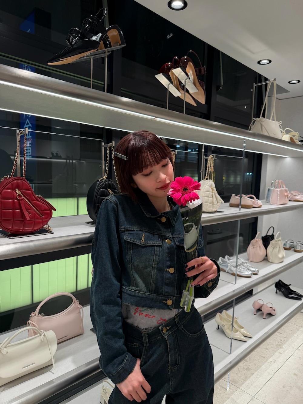 ブルー系のデニムジャケット、ブルー系のデニムパンツ、グレー系のベストを着用したレディースの春コーディネートの3枚目の写真