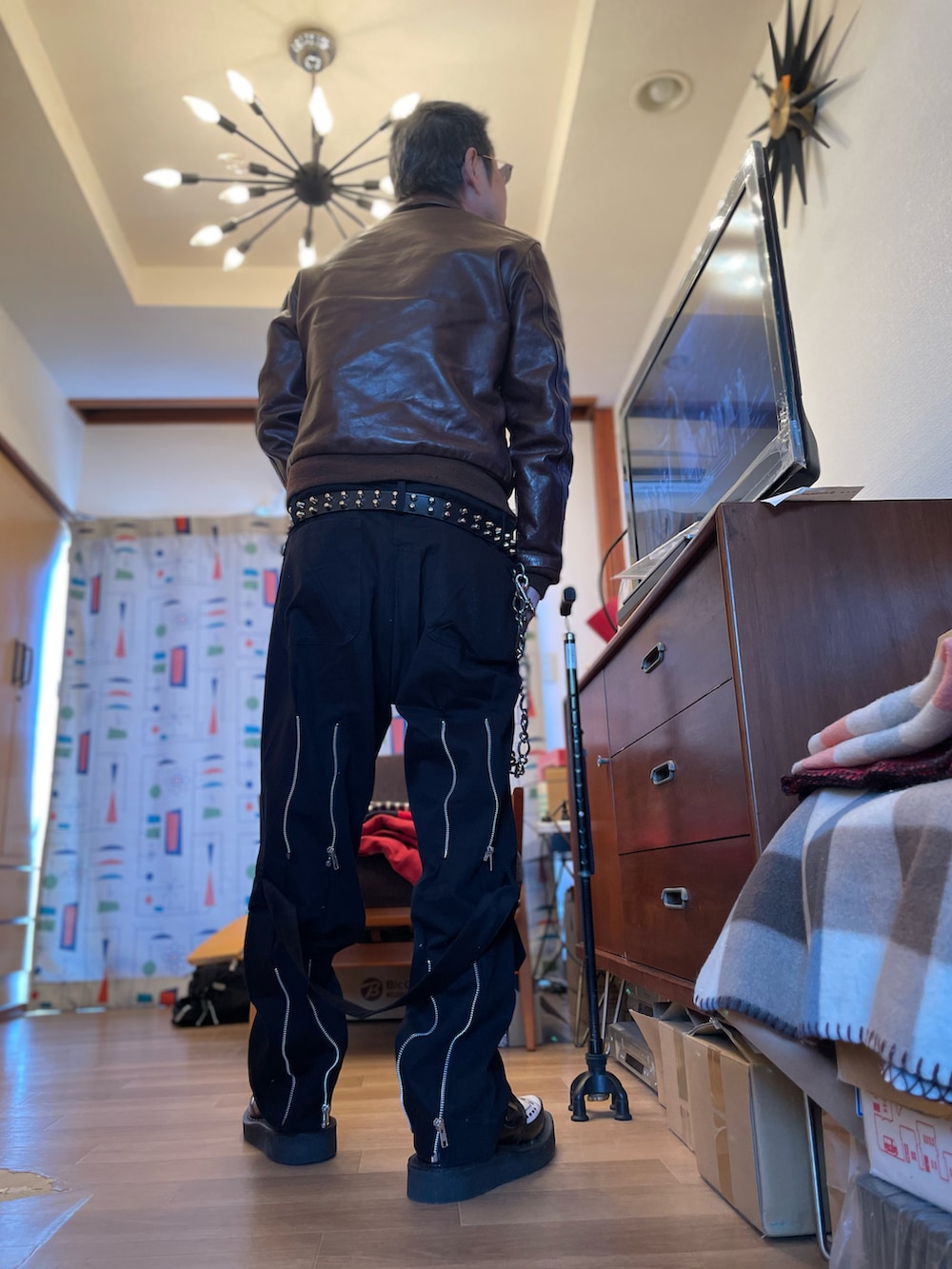 ブラウン系のミリタリージャケット、ブラック系のその他パンツ、その他のドレスシューズを着用したメンズの春コーディネートの4枚目の写真