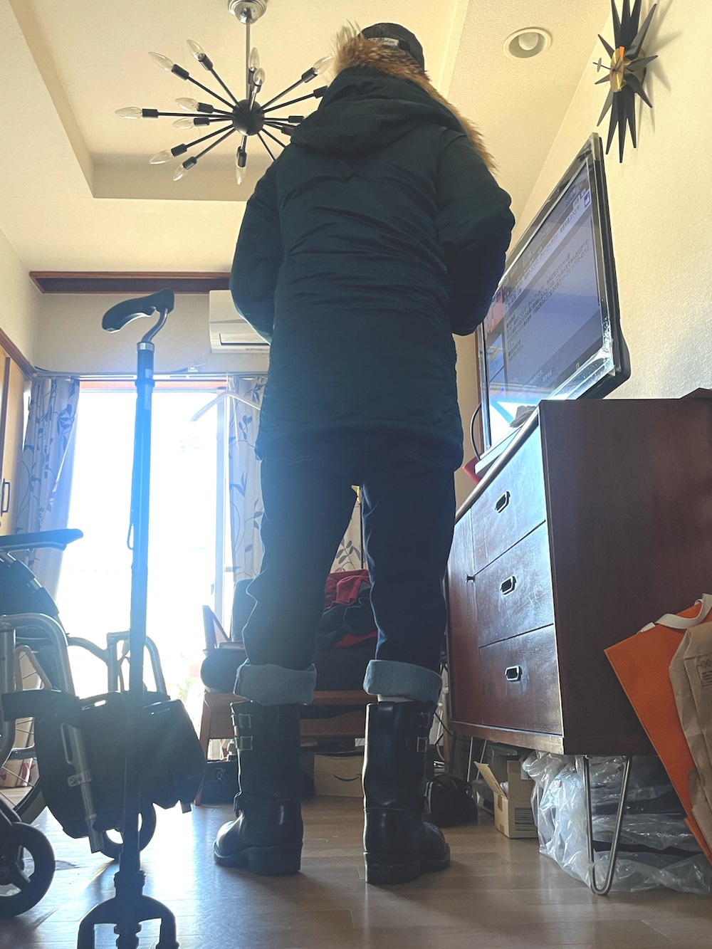 グリーン系のミリタリージャケット、ブルー系のデニムパンツ、ブラック系のブーツを着用したメンズの冬コーディネートの3枚目の写真