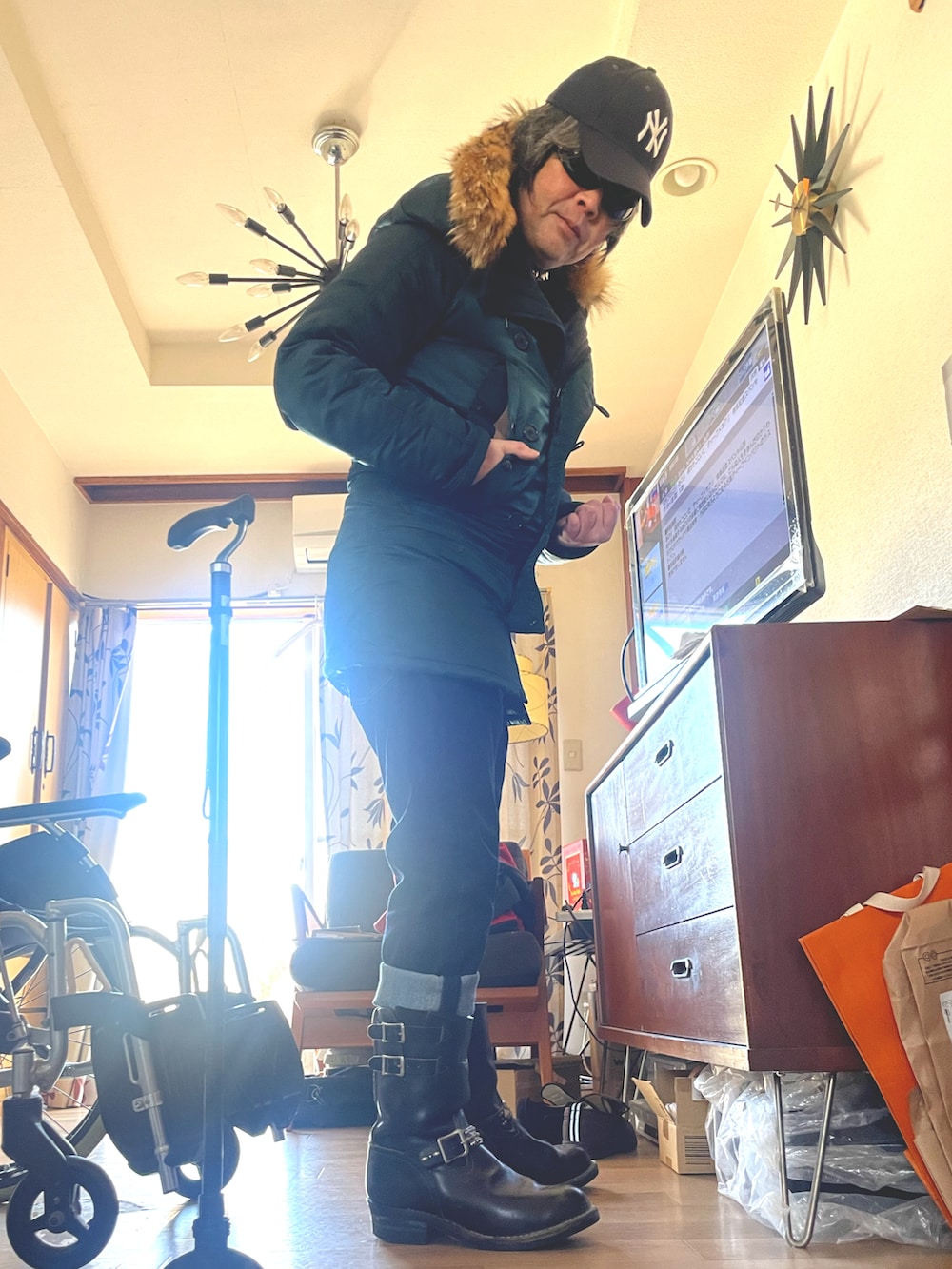 グリーン系のミリタリージャケット、ブルー系のデニムパンツ、ブラック系のブーツを着用したメンズの冬コーディネートの2枚目の写真