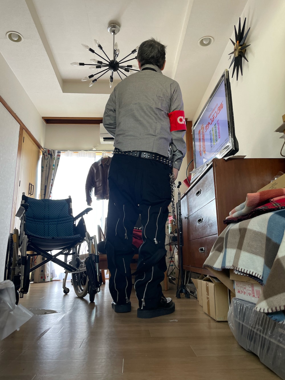 ブラウン系のミリタリージャケット、ブラック系のその他パンツ、その他のドレスシューズを着用したメンズの春コーディネートの3枚目の写真