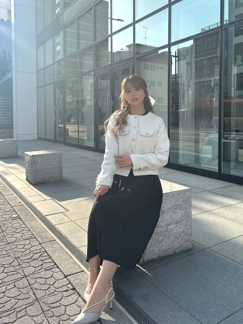 ホワイト系のノーカラージャケットを着用したレディースの冬コーディネートの3枚目の写真